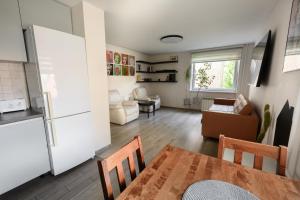 a kitchen and living room with a table and a refrigerator at Algirdo Apartments, Self Check-in, Free Private Parking in Vilnius
