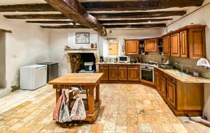 a large kitchen with wooden cabinets and a wooden table at Cottage À La Campagne in Mérigny