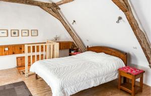 a bedroom with a white bed in a attic at Cottage À La Campagne in Mérigny