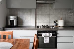a kitchen with a black stove and a wooden table at Algirdo Apartments, Self Check-in, Free Private Parking in Vilnius