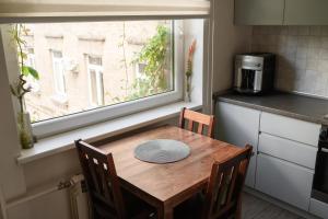 a kitchen with a wooden table and a window at Algirdo Apartments, Self Check-in, Free Private Parking in Vilnius