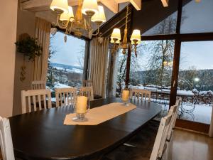 a dining room with a table and a large window at Chalet de Cligneval in Malmedy