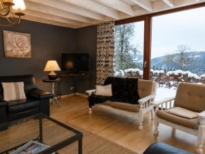 a living room filled with furniture and a large window at Chalet de Cligneval in Malmedy