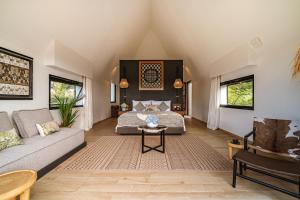 a living room with a bed and a couch at Buyan Lakeside Villas in Bedugul