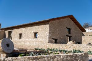 a stone building with a stone wall in front of it at EL BATAN Hotel & Spa in Castillo de Locubín