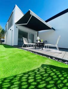 a patio with a table and chairs on a deck at Little White House in Anglet