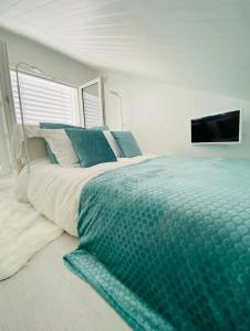 a bedroom with a bed and a tv on the wall at Little White House in Anglet