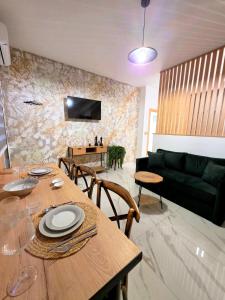 a living room with a table and a couch at Anthouli Homes 1, steps from beach and centre in Kardamaina
