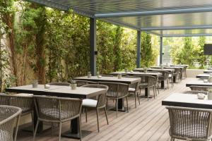 eine Reihe von Tischen und Stühlen auf einer Terrasse in der Unterkunft Divani Escape - Adults Only in Athen