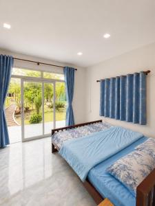 a bedroom with a bed and a large window at Garden Hostel Koh Rong in Koh Rong Island