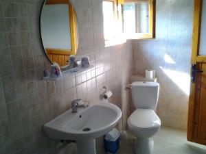 a bathroom with a sink and a toilet and a mirror at Vilele Brise de Mer in 2 Mai