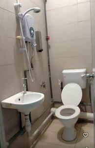 a bathroom with a toilet and a sink at SC Lodging Sinsuran Complex in Kota Kinabalu