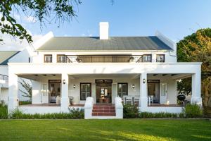 a white house with a green lawn at Winelands Golf Lodges 3 in Stellenbosch