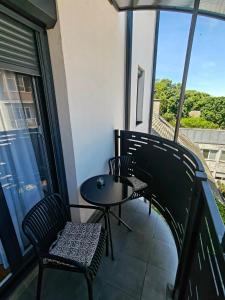 a patio with two chairs and a table on a balcony at Apartman JELENKO in Apatin +6 photos