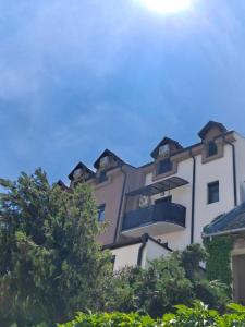 a tall building with trees in front of it at Apartman JELENKO in Apatin