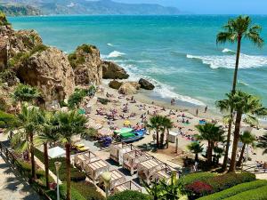 a beach with a bunch of people on the beach at La Casa Turquesa in Frigiliana