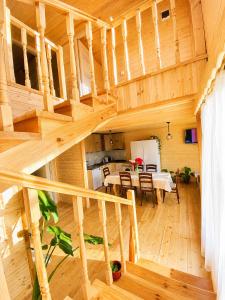 a wooden house with a staircase and a dining room at Zghapari Wooden Mountain Lodge in Aspindza