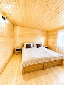a bedroom with a bed in a wooden room at Zghapari Wooden Mountain Lodge in Aspindza