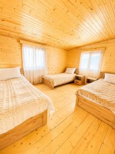 a bedroom with two beds in a wooden cabin at Zghapari Wooden Mountain Lodge in Aspindza
