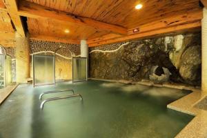 a large room with a stone wall and a floor with aitating at Sun Moon Bed& Breakfast 日月民宿 in Wulai