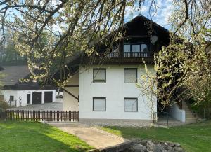 a white house with a balcony on top of it at Die Bartlmühle in Windorf
