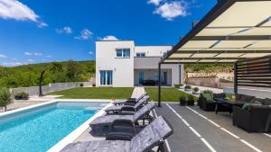 a backyard with a swimming pool and a house at Villa Luminosa by Villas Guide in Kraljevica