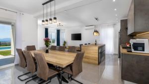 a kitchen and dining room with a wooden table and chairs at Villa Luminosa by Villas Guide in Kraljevica