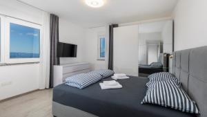 a bedroom with a bed with two pillows and a mirror at Villa Luminosa by Villas Guide in Kraljevica +24 photos