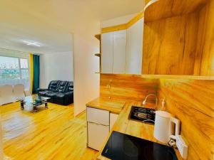 a kitchen with wooden floors and a living room at Yura Hostel in Darhan
