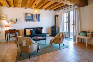 a living room with a blue couch and chairs at Gîte de caractère - La Grangette in Saint-Julien-le-Faucon