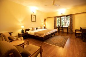 a bedroom with a bed and a living room at Sinna Dorai's Moulmein House in Vālpārai