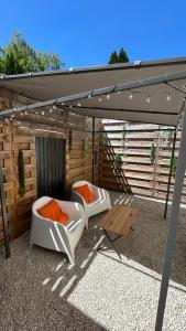two white chairs under an umbrella on a patio at Luana SPA Boussois in Boussois