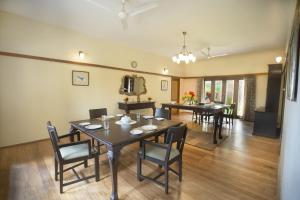 a dining room with a table and chairs in it at Sinna Dorai's Moulmein House in Vālpārai
