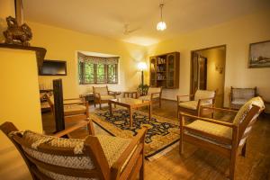 a living room with chairs and a table at Sinna Dorai's Moulmein House in Vālpārai