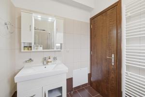 a bathroom with a sink and a wooden door at Villa Sarakinos in Kriniás +24 photos