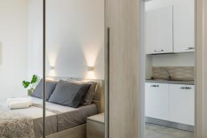 a bedroom with a bed and a kitchen with a sink at Elaia Bioglam Relais in Casa Modica