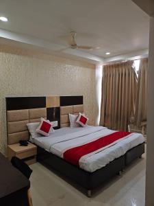 a bedroom with a large bed with red pillows at Hotel Travora Suits -Lalquila in Bhubaneshwar
