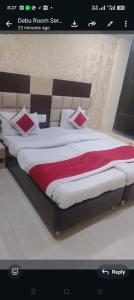 a bedroom with a large bed with red and white sheets at Hotel Travora Suits -Lalquila in Bhubaneshwar