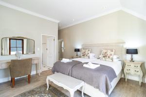 a bedroom with two beds and a desk and a mirror at Winelands Golf Lodges 10 in Stellenbosch +32 photos