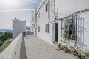 an alley with white buildings and a motorcycle on the street at Vejer de la frontera 100 pza España in Vejer de la Frontera