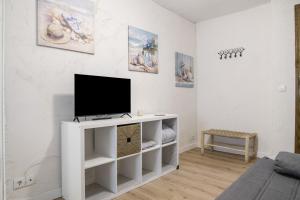 a living room with a tv on a white cabinet at Vejer de la frontera 100 pza España in Vejer de la Frontera