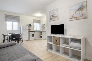 a living room with a bed and a flat screen tv at Vejer de la frontera 100 pza España in Vejer de la Frontera