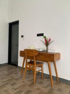 a wooden table and a chair next to a desk at Cozzy Sagas House Tabanan in Perean