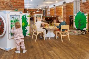 a group of children playing a board game in a store at Pühajärve Spa & Holiday Resort in Otepää