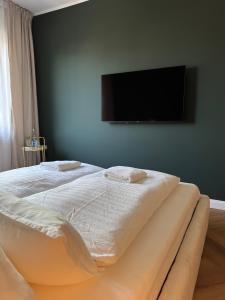 a bedroom with a bed with a tv on the wall at Westerntor City Studio in Paderborn