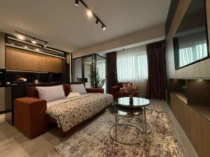 a bedroom with a bed and a table and a couch at Zen studio near Mall Moldova in Iaşi