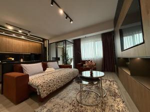 a living room with a bed and a table at Zen studio near Mall Moldova in Iaşi