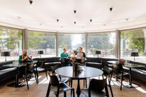 a group of people sitting at tables in a restaurant at Pühajärve Spa & Holiday Resort in Otepää