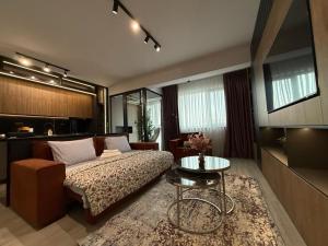 a living room with a bed and a table at Zen studio near Mall Moldova in Iaşi