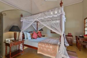 a bedroom with a canopy bed with a table and a desk at Villa Sethawadi Hotel and Kitesurf Centre in Kalpitiya +45 photos